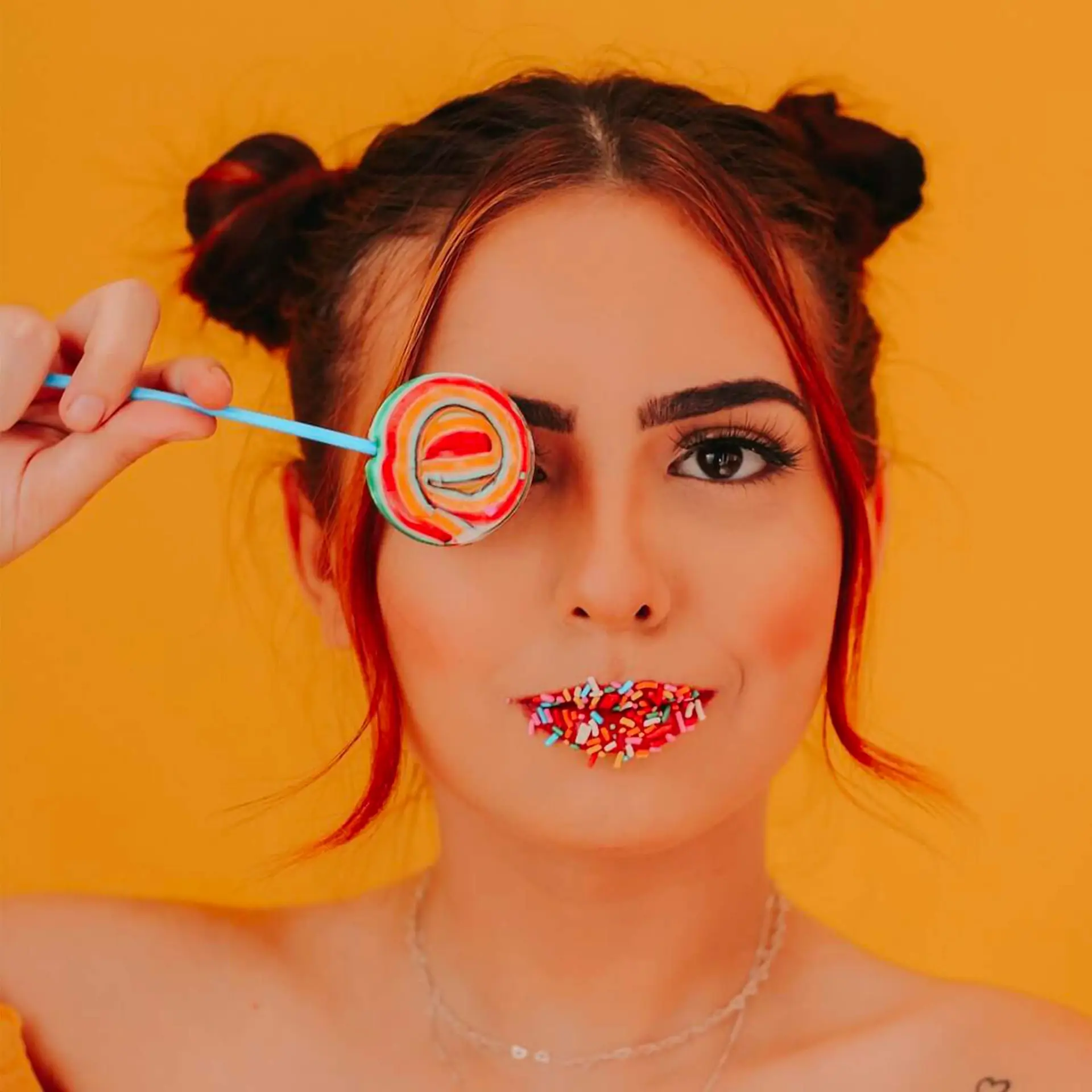 femme posant avec une sucette Lollipops devant son visage